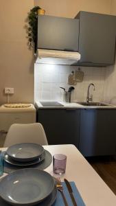 a kitchen with a table with plates and a sink at Casa Agata in Chioggia +8 photos