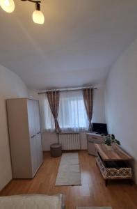 a living room with a table and a large window at Enjoy Eden in Constanţa