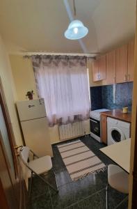a small kitchen with a refrigerator and a window at Enjoy Eden in Constanţa