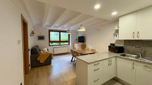 a kitchen and living room with a couch and a table at BPirineos-Mulleres in Benasque