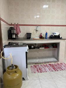 a kitchen with a stove and a counter top at Excelente apartamento espaçoso com terraço in Macaé