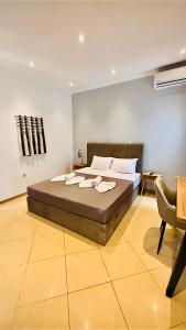 a bedroom with a large bed and a chair at Fay's Apartment in Limenas