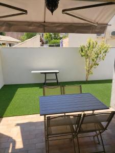 a blue table and two chairs under an umbrella at Maison 80 m2 - proche des plages in Montpellier