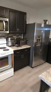 a kitchen with black cabinets and a stainless steel refrigerator at North in Camby +19 photos