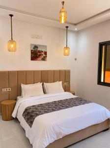 a bedroom with a large bed with white sheets at Spinoza House Agadir City Apartment in Agadir