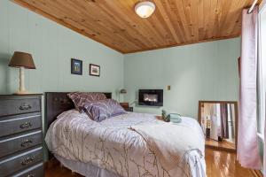 a bedroom with a bed and a wooden ceiling at Brigus Cottage Parking, Fire Pit & Garden in Brigus