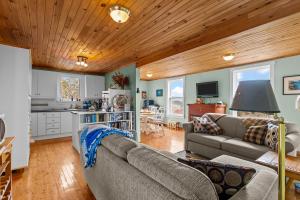 a living room with a couch and a kitchen at Brigus Cottage Parking, Fire Pit & Garden in Brigus