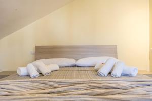 a bed with four pillows on top of it at Fly&Rest Ciampino in Ciampino