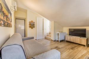 a living room with a couch and a television at Fly&Rest Ciampino in Ciampino