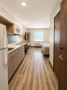 a kitchen with wooden floors and a bed in a room at WoodSpring Suites Jackson Hub City in Jackson