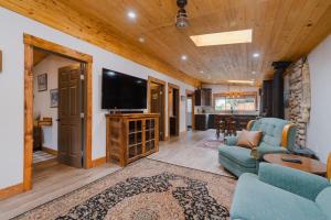 a living room with a couch and a tv at Rustic Old West Cabin 1 Block to Beach Accessible Private Yard in Sylvan Lake
