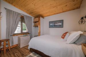 a bedroom with a white bed and a wooden ceiling at Rustic Old West Cabin 1 Block to Beach Accessible Private Yard in Sylvan Lake