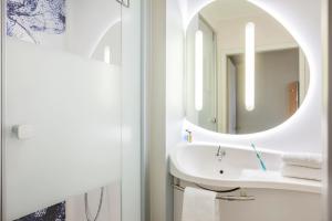 a bathroom with a sink and a mirror at Ibis Budget Mulhouse Centre Gare in Mulhouse +19 photos