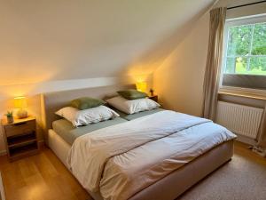 a bedroom with a bed with two pillows and a window at Haus Muhblick in Schmallenberg
