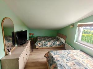 a bedroom with two beds and a tv and a window at Žangrija in Verbiškis