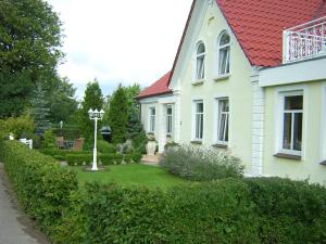 a white house with a red roof and a yard at Schulwald in Westerholz