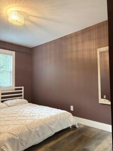 a bedroom with a bed and a brown wall at Brookswood Oasis - Guest suite,1 bedroom,1 den & 1 full bathroom in Langley +11 photos