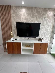 a flat screen tv sitting on top of a cabinet at The Liras Oasis in Santiago de los Caballeros