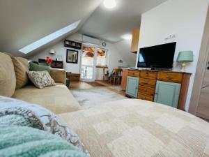 a living room with a couch and a flat screen tv at Fenyves Appartman in Pécsely
