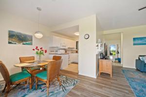a dining room and living room with a table and chairs at Makai Dream (Oceanfront) in Lihue
