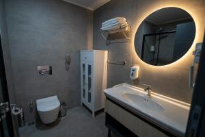 a bathroom with a sink and a mirror and a toilet at Demederon Hotel in Hamsikoy