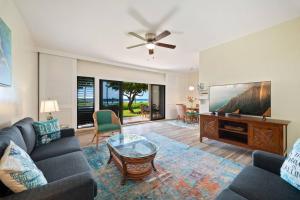 a living room with a couch and a tv at Makai Dream (Oceanfront) in Lihue