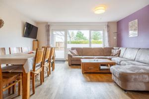 a living room with a couch and a table at Bungalow Windstille in Norddeich