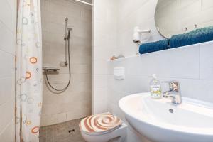 a bathroom with a sink and a toilet and a mirror at Bungalow Windstille in Norddeich +10 photos