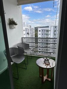 a balcony with a table and chairs and a window at The Liras Oasis in Santiago de los Caballeros