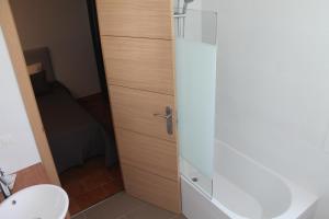 a bathroom with a toilet and a glass shower door at Hostal Montilla Sotogrande in Torreguadiaro