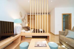 a living room with a couch and a tv at Apartamentos Mercat in Valencia