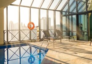 a room with a swimming pool and a building with windows at Radisson Oscar Freire in São Paulo +150 photos