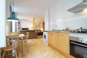 a kitchen and living room with a table and chairs at Flatsforyou Mercat in Valencia