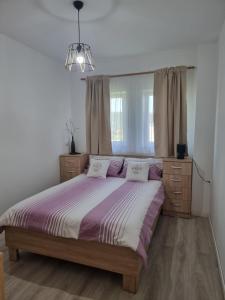 a bedroom with a bed with purple and white sheets at Cozy Lake House in Cinciş
