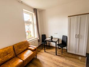 a living room with a couch and a table at Modernes Apartment mit Küche in Groitzsch in Groitzsch