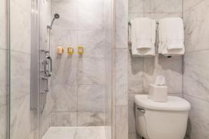 a white bathroom with a shower and a toilet at Madison Square Hotel Near NoMad in New York
