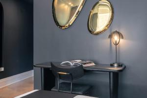 a desk with a lamp and a mirror on a wall at Madison Square Hotel Near NoMad in New York