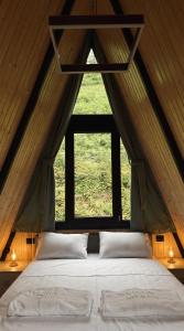 a bed in a room with a large window at Villa MERISI in Merisi