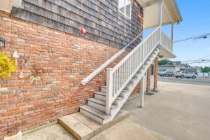 a brick building with a white staircase next to a house at Between Tides 3BR Walk to Beach Unit D in Seaside Park
