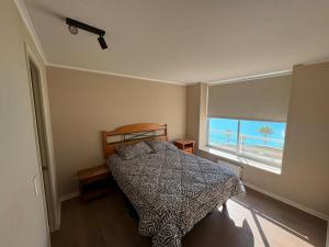 a bedroom with a bed with a view of the beach at Laguna Bahia Velero in Algarrobo +29 photos