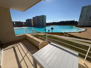 a balcony with a bench and a view of the water at Laguna Bahia Velero in Algarrobo
