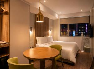 a hotel room with a bed and a table and a bed and a window at Hotel Relax II in Taipei