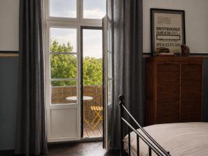 a bedroom with a door open to a balcony at Maisonnette Clisson quartier Trinité in Clisson