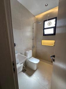 a bathroom with a toilet and a sink and a window at The Pearl Inn in Nizwa