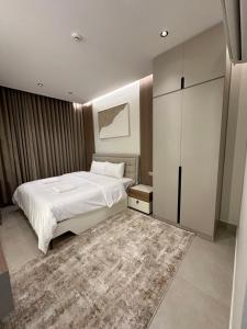a bedroom with a white bed and a rug at The Pearl Inn in Nizwa