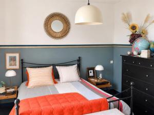 a bedroom with a bed with an orange blanket at Maisonnette Clisson quartier Trinité in Clisson