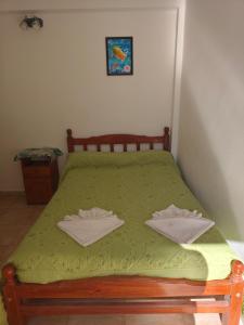 a bedroom with a green bed with two towels on it at Hospedaje Dos Soles - Centro in Termas de Río Hondo +29 photos