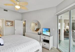 a white bedroom with a bed and a mirror at Bay view Siesta Key condo - two pools - tennis and pickleball - beach access - GBB 1343 in Siesta Key