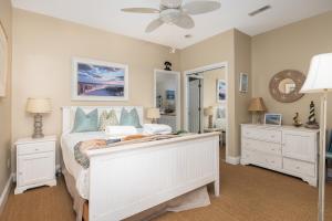 a bedroom with a white bed and a mirror at Beachwalk Villas 22 in Folly Beach