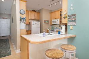 a kitchen with a sink and a counter with stools at Beachwalk Villas 22 in Folly Beach +19 photos